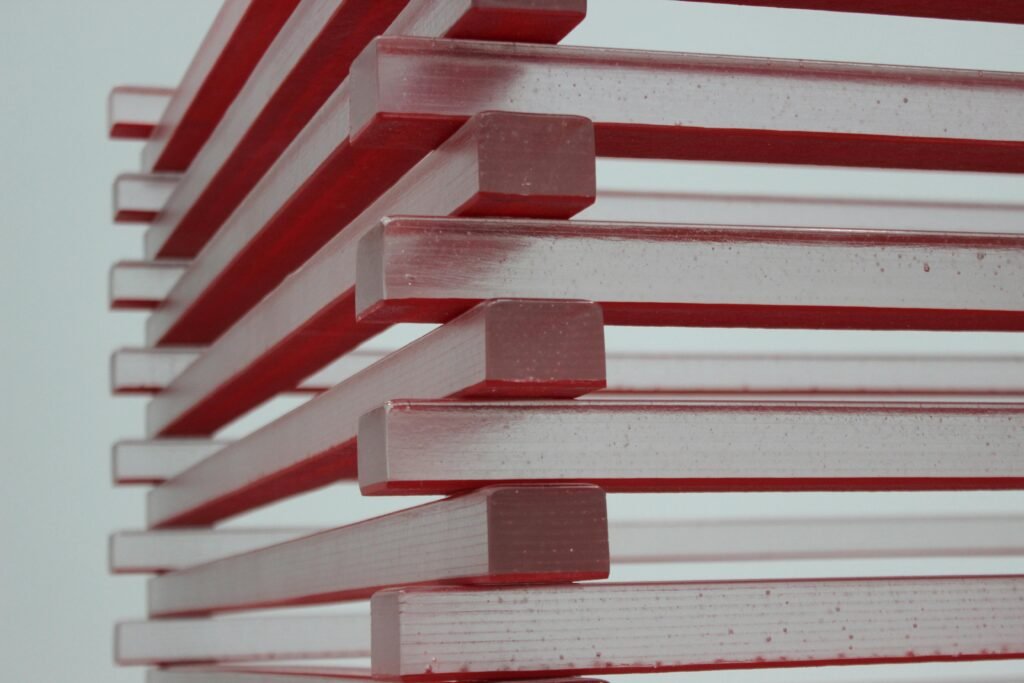 Close-up view of stacked red and clear blocks creating an abstract geometric pattern.